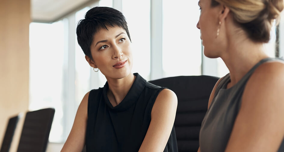 Two women sat looking at each other